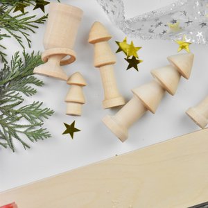 Foto mit Weihnachtsbäumen aus Holz auf einem weißen Tisch