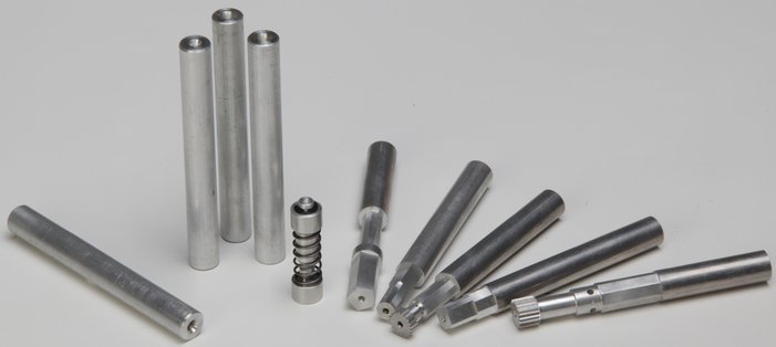 Aluminiumrohling rund mit fertigen Modellen auf einem Tisch